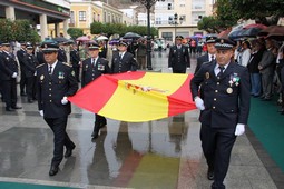 Agentes-de-la-Policia-Local-portan-la-bandera-nacional-que-se-ha-izado-en-el-mastil-del-monumento-que-preside-la-Plaza-de-la-Constitución