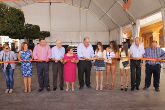La reina de las fiestas, ayudada por el alcalde, corta la cinta con la que se inaugura oficialmente la Feria del Mediodía