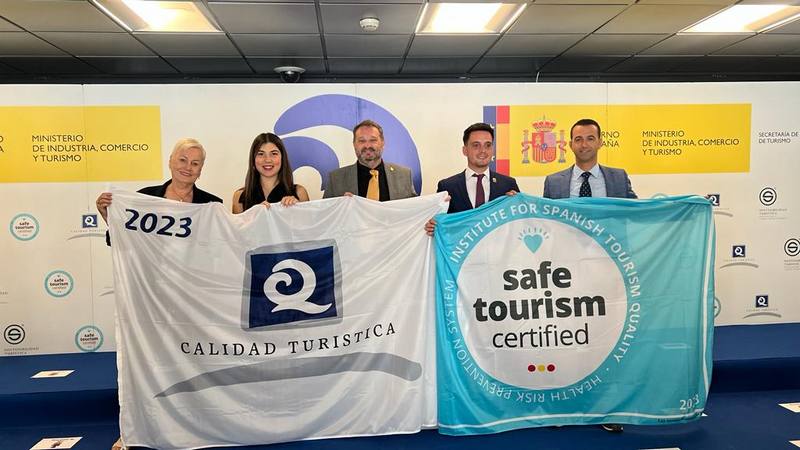 Teniente de alcalde y edil de Playas de Pulpí recogiendo las banderas Q de Calidad Turística